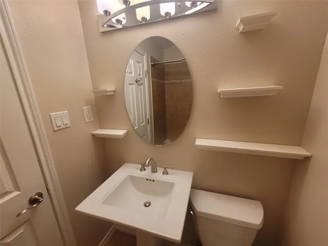 a bathroom with a toilet sink and mirror