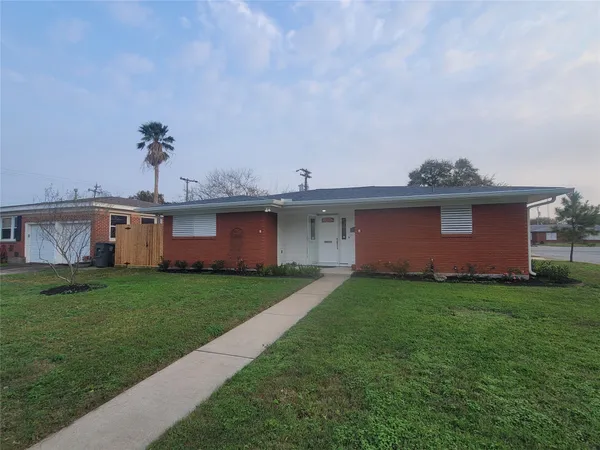 a view of a yard in front of a house with a large tree