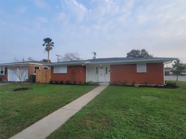 a view of a yard in front of a house with a large tree