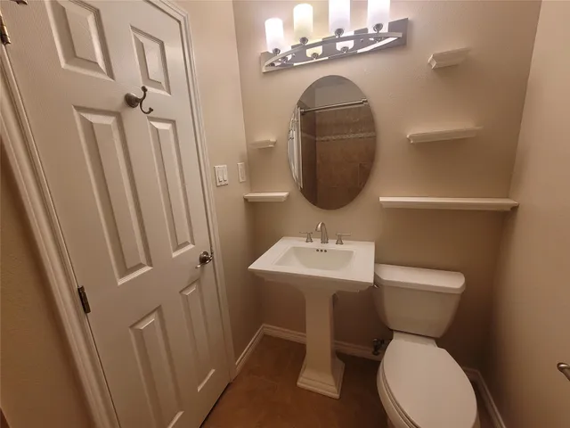 a bathroom with a toilet sink and mirror