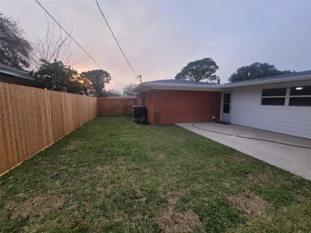 a view of a backyard with plants and a fence