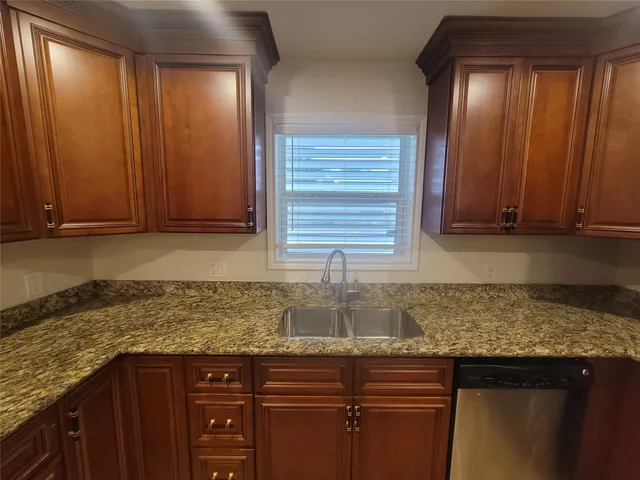 a kitchen with granite countertop a sink and cabinets