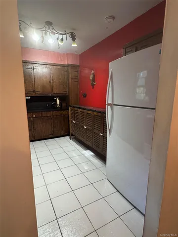 a kitchen with granite countertop a refrigerator and a sink