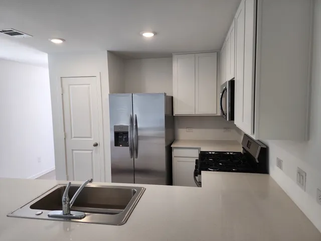 a kitchen with stainless steel appliances granite countertop a refrigerator and a stove