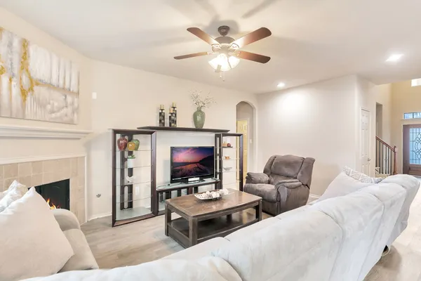 a living room with furniture a fireplace and a chandelier