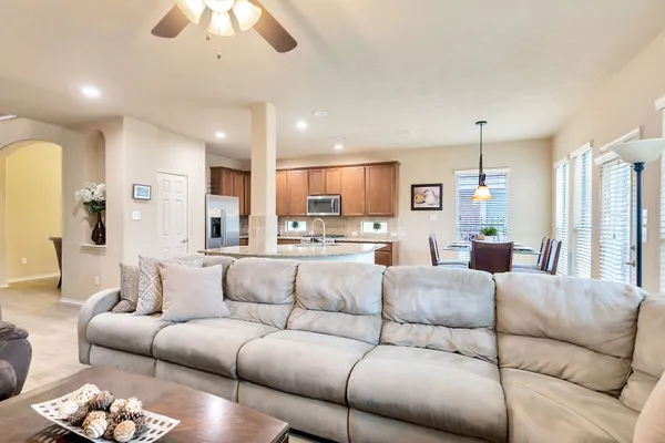 a living room with furniture kitchen and a chandelier