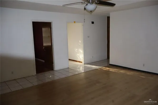 an empty room with a ceiling fan and carpet