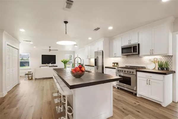 a kitchen with stainless steel appliances a stove sink microwave and cabinets