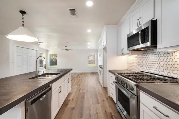 a kitchen with stainless steel appliances granite countertop a sink and a stove