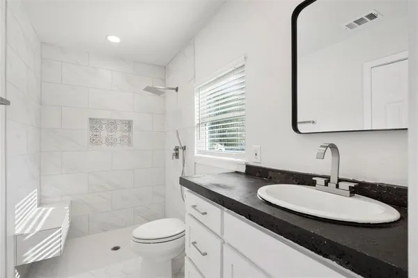 a bathroom with a sink a toilet and a mirror