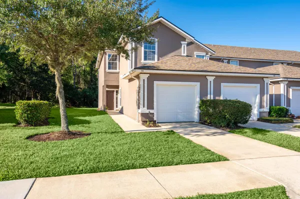 a front view of a house with a yard and garage