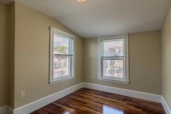 an empty room with wooden floor and closet