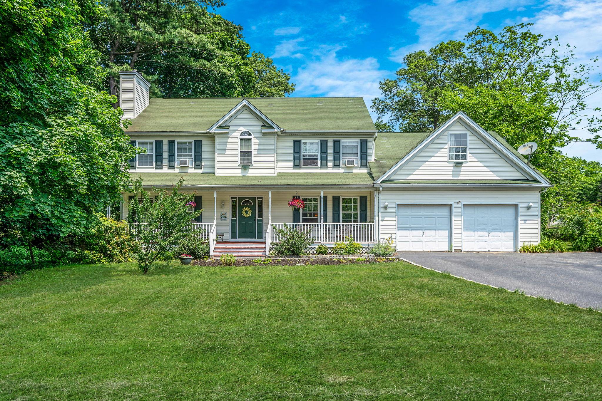 a front view of a house with a yard and trees