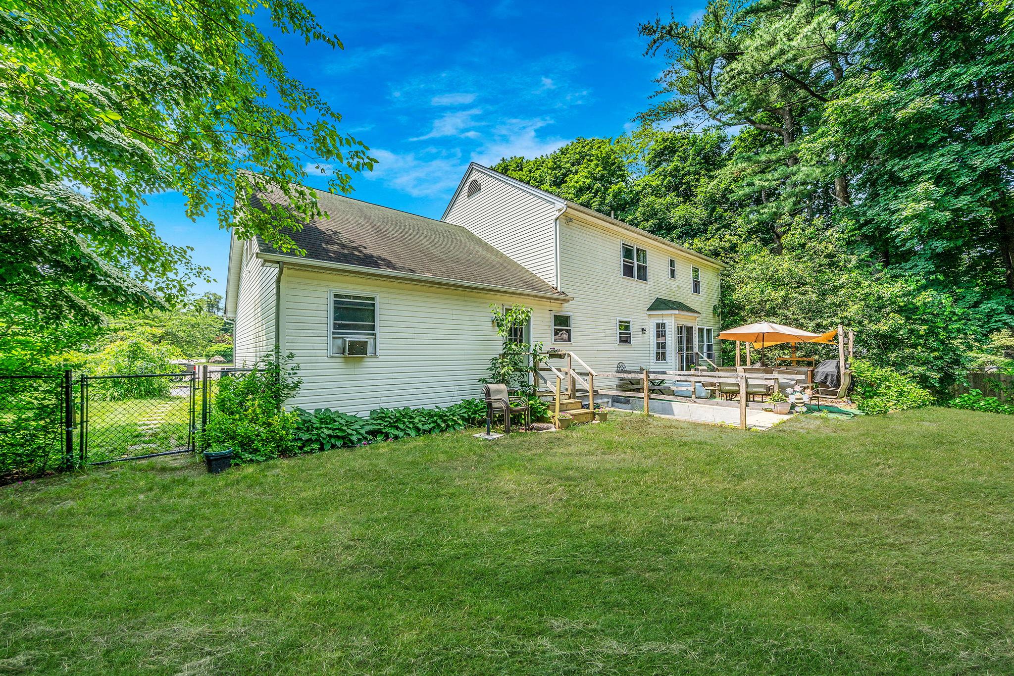 4 Ariel Court Rocky Point, NY 11778 - Photo 41 of 45 a backyard of a house with table and chairs plants and large tree