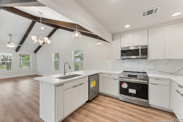 a kitchen with stainless steel appliances a sink dishwasher stove and refrigerator