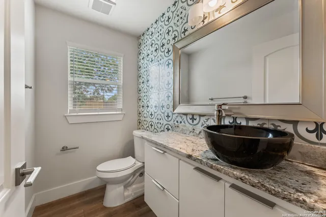 a bathroom with a granite countertop sink toilet and shower