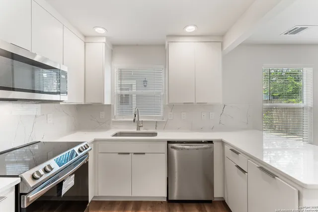 a kitchen with a sink appliances and cabinets
