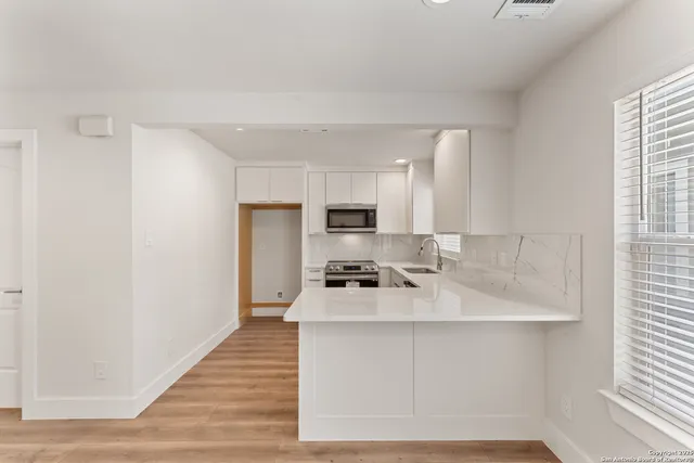 a view of an empty room with wooden floor