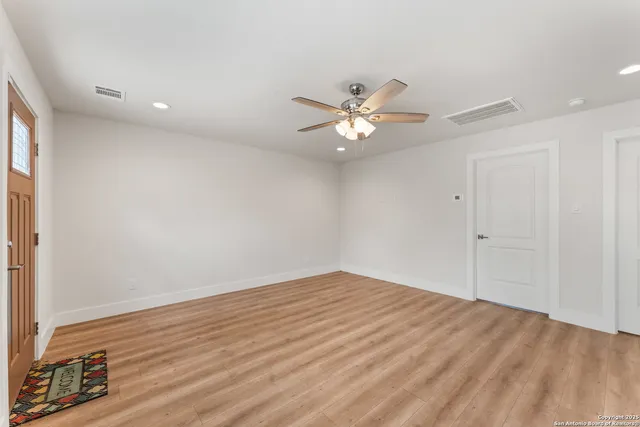 a view of a livingroom with a kitchen stove wooden floor and window