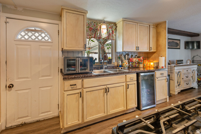 255 North 1600 West, Unit 60 Provo, UT 84601 - Photo 7 of 22 Kitchen with light wood finish cabinetry, dark countertops, tasteful backsplash, and wine cooler