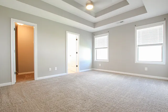 an empty room with windows and closet