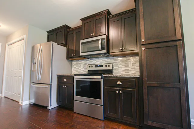 a kitchen with stainless steel appliances granite countertop a refrigerator and a stove