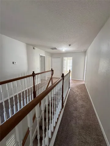 a view of a hallway with wooden floor and windows