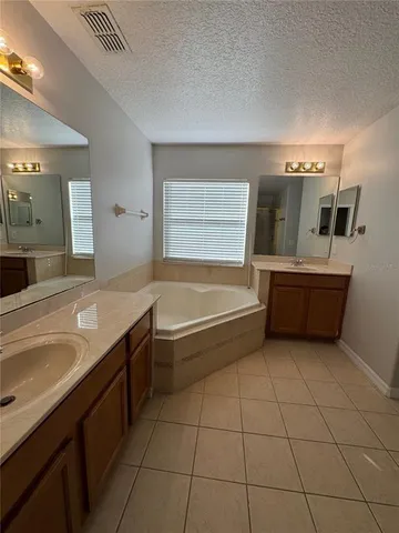 a bathroom with a tub sink and mirror