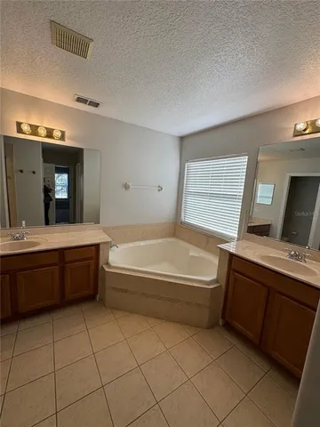a bathroom with a tub sink and mirror