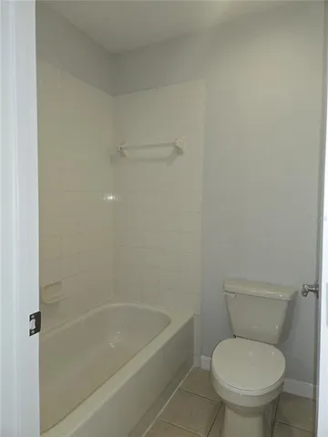 a white toilet sitting next to a bath tub