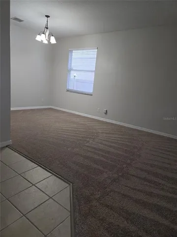 en empty room with windows and ceiling fan