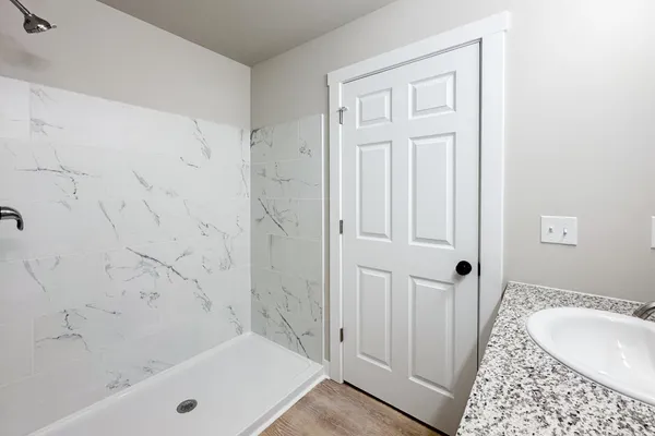 a bathroom with a tub shower and sink