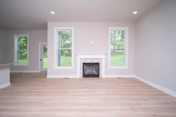 a view of an empty room with a window and a fireplace