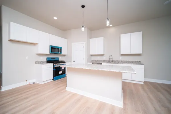 a kitchen with kitchen island white cabinets and appliances