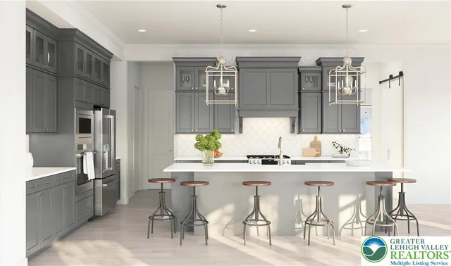 a kitchen with stainless steel appliances kitchen island granite countertop a refrigerator and cabinets