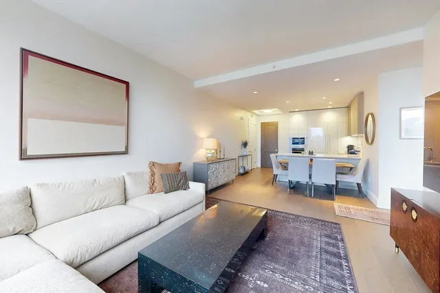a living room with furniture and a dining table with kitchen view