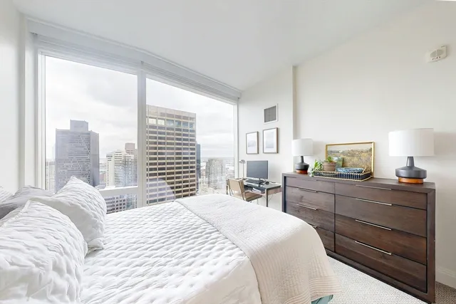 a bedroom with a bed and large window