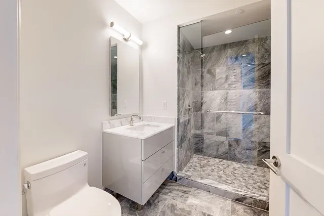 a bathroom with a shower sink and mirror