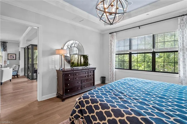 a bedroom with a bed a dresser and wooden floor