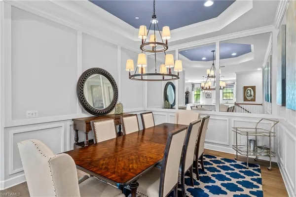 a dining room with furniture a chandelier and wooden floor