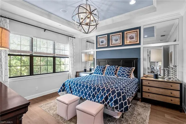 a bedroom with a bed and a chandelier