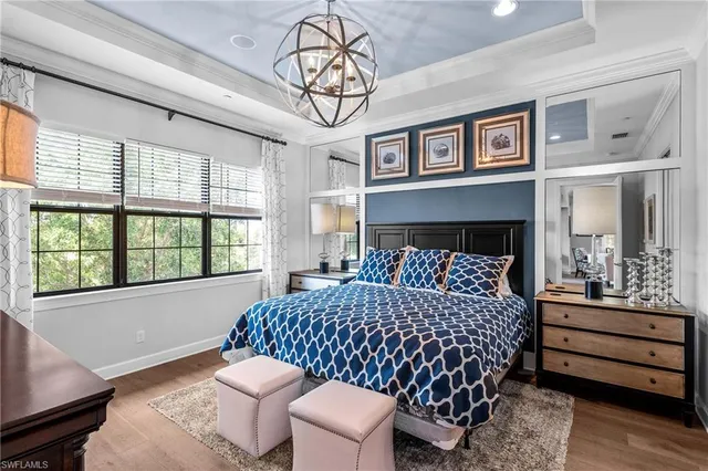 a bedroom with a bed and a chandelier