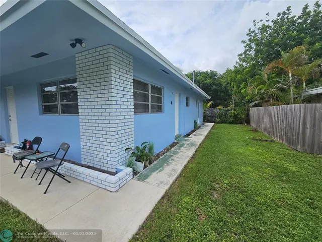 a backyard of a house with table and chairs