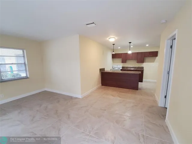 a kitchen with kitchen island a sink and a stove top oven with granite countertops