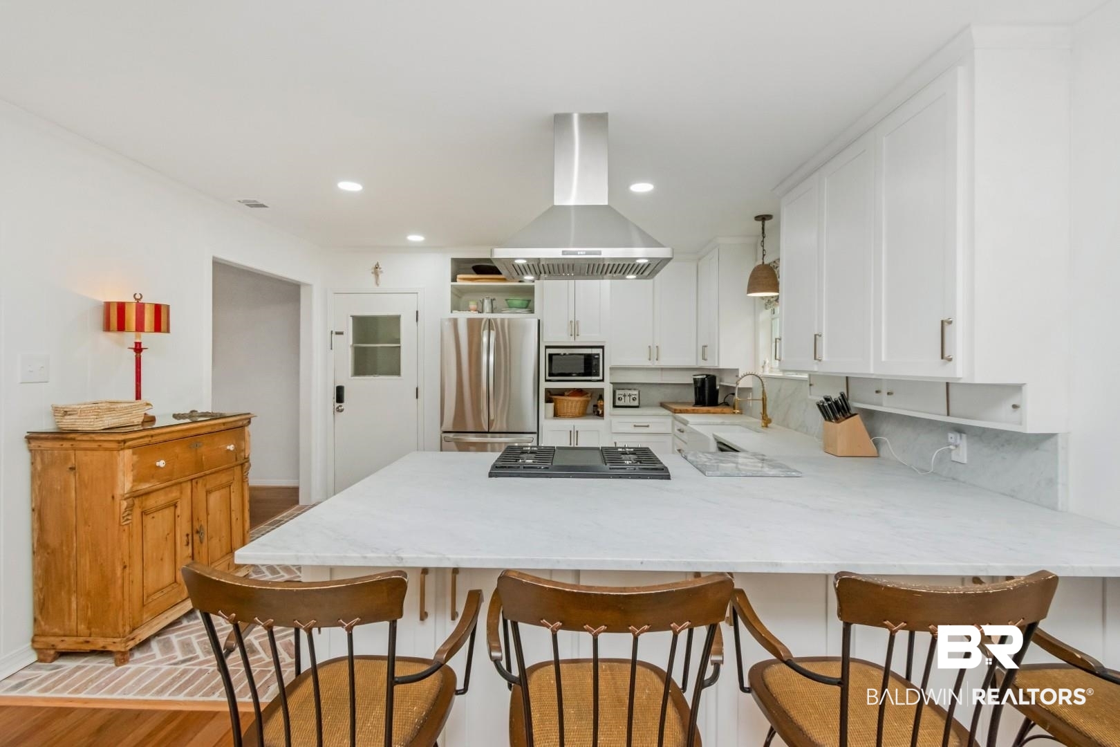 4596 Hawthorne Place Mobile, AL 36608 - Photo 14 of 34 Kitchen featuring white shaker cabinetry, stainless steel appliances, a range hood, and a built-in cooktop on a light-toned countertop