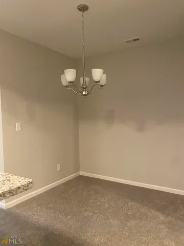 a view of a room with a hanging light and kitchen