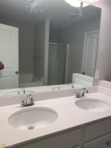 a bathroom with double vanity sinks and a mirror