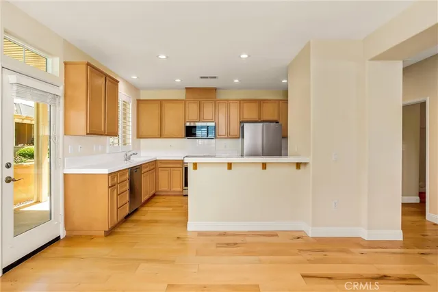 a large kitchen with stainless steel appliances granite countertop a stove a sink and a refrigerator