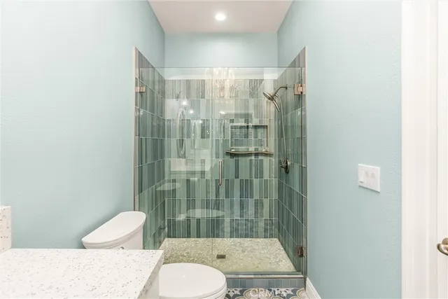 a bathroom with a granite countertop toilet and a shower
