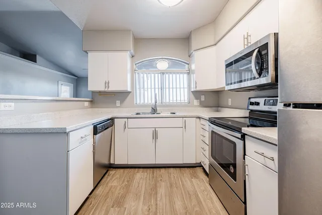 a kitchen with a sink stove top oven and cabinets